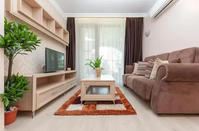 a living room with a couch and a tv at Harmony Suites Saint Vlas in Sveti Vlas