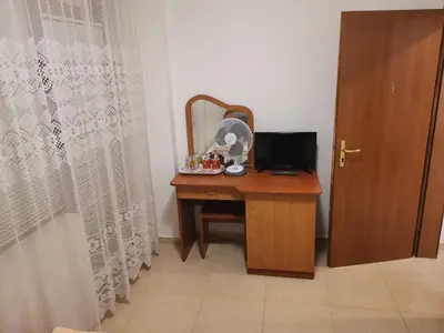 a desk with a mirror and a computer on it at Къща за гости Кадиеви in Primorsko
