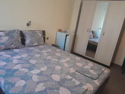 a bedroom with a bed and a large mirror at Апартаменти и стаи Анхиало in Pomorie
