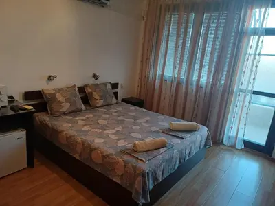 a bedroom with a bed with two pillows on it at Апартаменти и стаи Анхиало in Pomorie