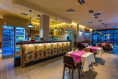 a restaurant with tables and chairs and a bar at Hotel Provadia in Provadiya