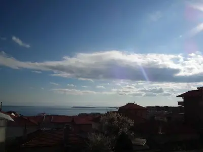 a rainbow in the sky over a city at Guest House Olimpiya in Sveti Vlas