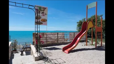 a playground with a slide in the sand near the ocean at Hotel Fantasy Beach in Sveti Vlas