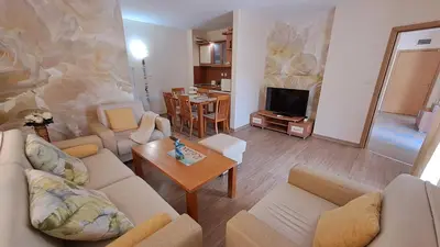 a living room with two couches and a television at Aquaria Holiday Apartments in Sunny Beach