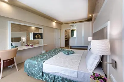 a bedroom with a bed and a table and a chair at Siena Palace in Primorsko