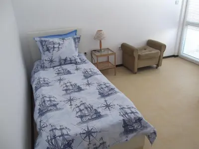 a bedroom with a bed with a black and white comforter at Apartment Sredna Gora in Burgas City