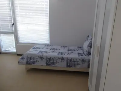 a bedroom with a bed in a room with windows at Apartment Sredna Gora in Burgas City