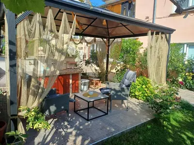 a patio with an umbrella and chairs and a table at Dom Zaharievi in Byala