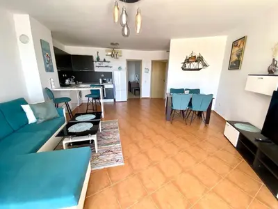 a living room with a couch and a table and chairs at Apartments Bellevue in Ravda