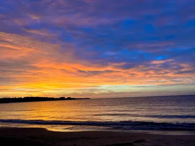 a sunset on a beach with the ocean and the sky at Apartments Bellevue in Ravda