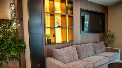 a living room with a couch and a tv at Aparthotel Paradiso in Nesebar