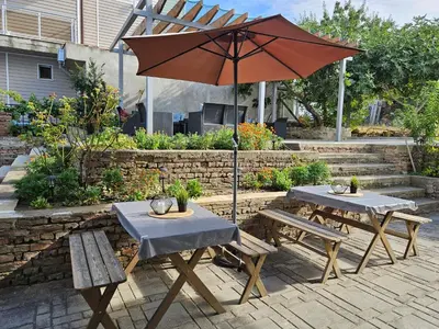 two tables and an umbrella in a garden at Family House Manolov in Obzor