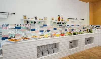 a kitchen with plates of food on a counter at Calypso Hotel - All Inclusive in Sunny Beach