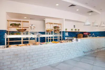 a restaurant with a counter with food on it at Calypso Hotel - All Inclusive in Sunny Beach