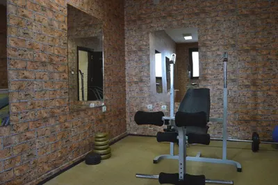 a room with a gym with mirrors and chairs at Hotel Eos in Kiten