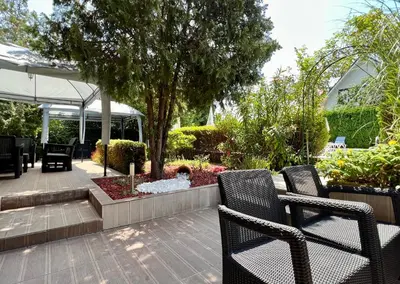 a patio with two chairs and a fountain in a garden at Family Hotel Kontesa in Lozenets