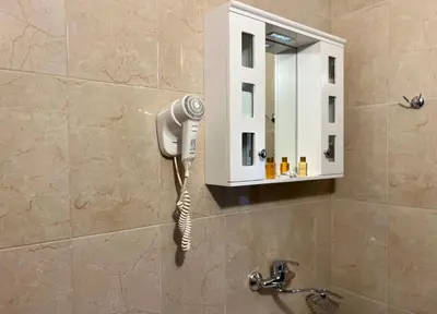 a hair dryer on a wall next to a mirror at Family Hotel Kontesa in Lozenets