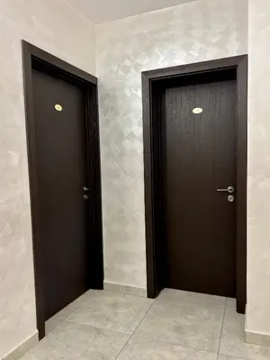 two brown doors in a room with tiles at Family Hotel Kontesa in Lozenets