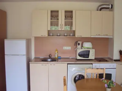 a kitchen with a washing machine and a microwave at Green Fort Noks Apartments in Sunny Beach