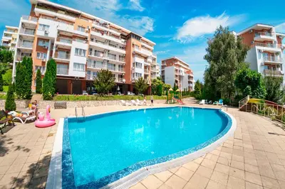 a swimming pool in front of some apartment buildings at Crown Fort Club in Sveti Vlas