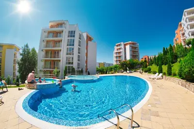 a large swimming pool in a city with buildings at Crown Fort Club in Sveti Vlas