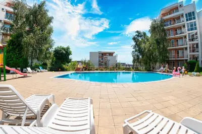 a swimming pool with chairs and a slide at Crown Fort Club in Sveti Vlas