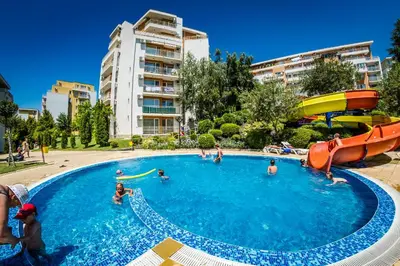 a group of people in a pool with a water slide at Imperial and Crown Fort Noks Grand Resort in Sveti Vlas