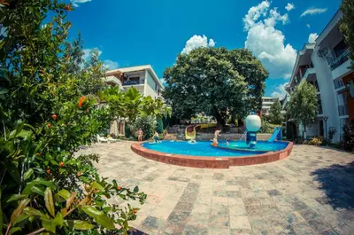a pool in a courtyard with people playing in it at Messambria Fort Noks Beach Apartments in Elenite
