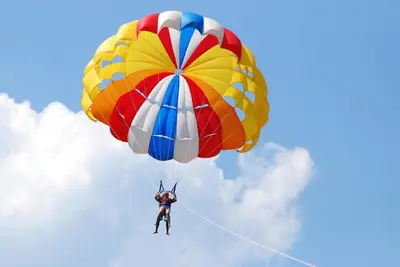 a person riding a parachute in the sky at Messambria Fort Noks Beach Apartments in Elenite