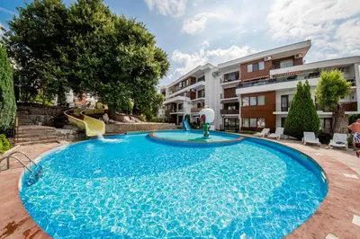 a large blue pool with a slide in a building at Messambria Fort Noks Beach Apartments in Elenite