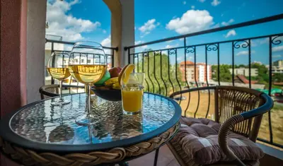 a table with two glasses of wine on a balcony at Step Hotel in Sunny Beach