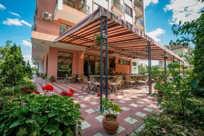 an outdoor patio with tables and chairs and flowers at Step Hotel in Sunny Beach