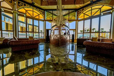 a lobby with a large room with chairs and a vase at Imperial Palace Hotel in Sunny Beach