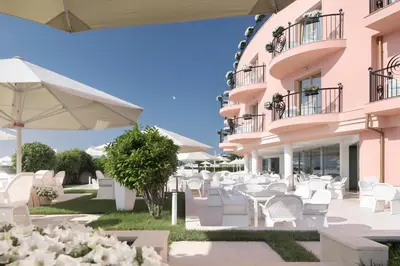 a hotel patio with white chairs and tables and umbrellas at Hotel Residence Dune - Free Beach Access in Sunny Beach