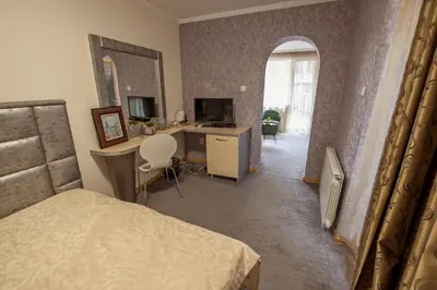a bedroom with a bed and a desk with a computer at Hotel Perfect in Varna City