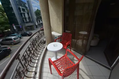 a balcony with a table and chairs and a street at Hotel Perfect in Varna City