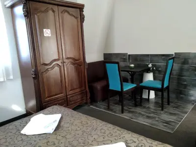 a room with a table and two blue chairs at Hotel Perfect in Varna City