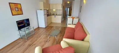a living room with a couch and a tv and a kitchen at Julia Family Apartments in Sunny Beach