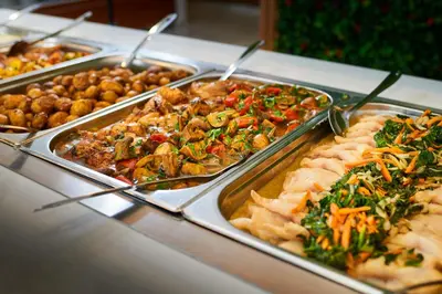 a buffet with several trays of food on a table at Hotel Bavaro in Sunny Beach