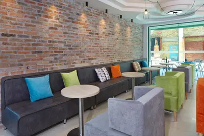 a room with a couch and tables and a brick wall at Hotel Aktinia - All Inclusive in Sunny Beach
