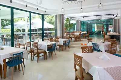 a restaurant with tables and chairs and windows at Hotel Aktinia - All Inclusive in Sunny Beach