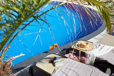 a picnic table with a hat next to a pool at Hotel Nobel Ultra All Inclusive - FREE Beach Access in Sunny Beach
