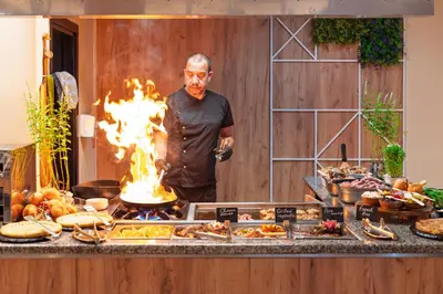 a man standing in front of a buffet of food at Hotel Nobel Ultra All Inclusive - FREE Beach Access in Sunny Beach