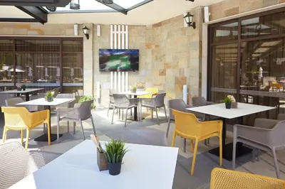 a restaurant with tables and chairs and a tv on the wall at Hotel Nobel Ultra All Inclusive - FREE Beach Access in Sunny Beach