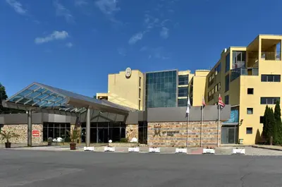 a large building with flags in front of it at Les Magnolias Hotel in Primorsko