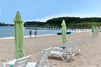 a group of chairs and umbrellas on a beach at Villas Holidays in Primorsko