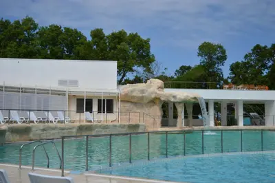 a swimming pool with a water fountain in front of a building at Villas Holidays in Primorsko