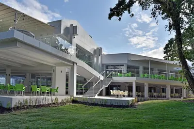 a large white building with green chairs and tables at Villas Holidays in Primorsko