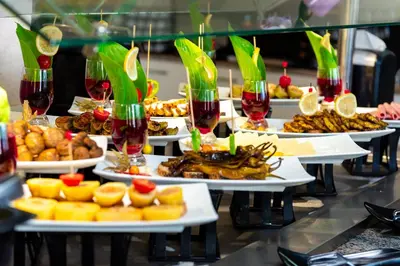 a buffet line with plates of food and glasses of wine at Hotel Sunny in Sozopol