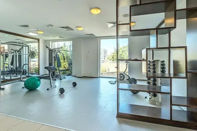 a gym with exercise equipment and a large window at Festa Pomorie Resort in Pomorie